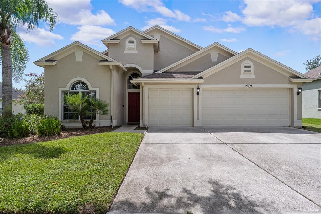 5909 Wedgefield Drive Zephyrhills, FL 33541 - Photo 34 of 54 a front view of a house with a yard and potted plants