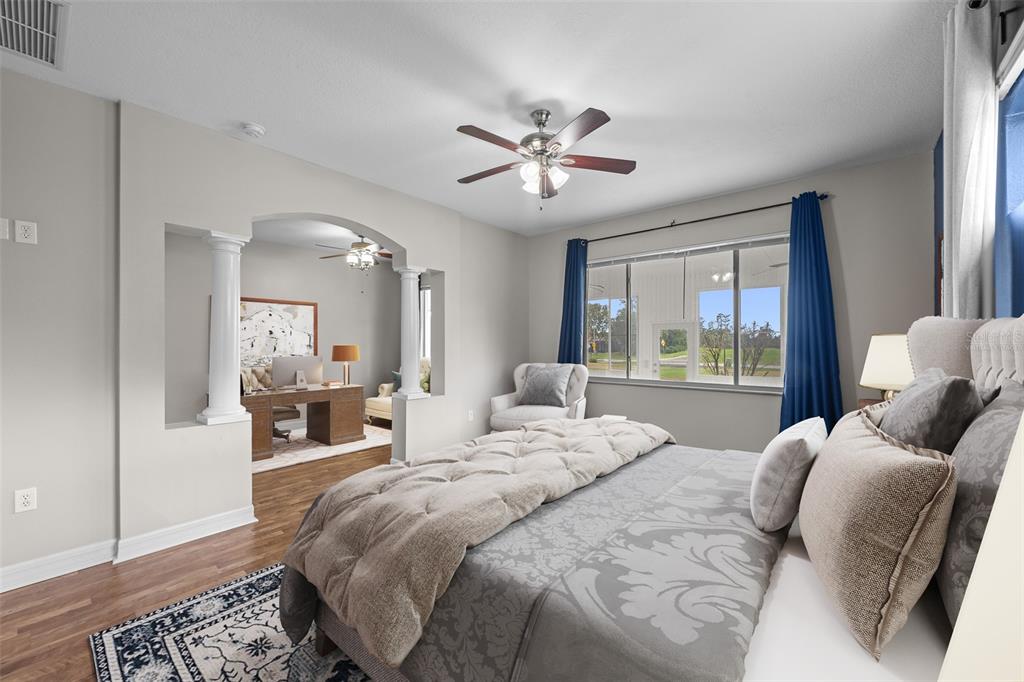 5909 Wedgefield Drive Zephyrhills, FL 33541 - Photo 7 of 54 a bedroom with a large bed and a chandelier