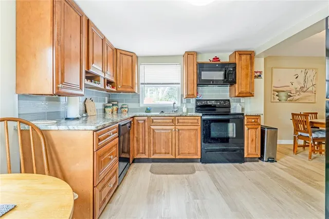 a kitchen with stainless steel appliances granite countertop a stove a sink and a refrigerator