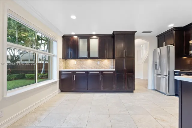 a large kitchen with stainless steel appliances granite countertop a refrigerator and a sink