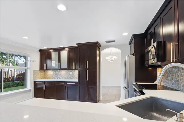 a kitchen with stainless steel appliances granite countertop a refrigerator and a sink