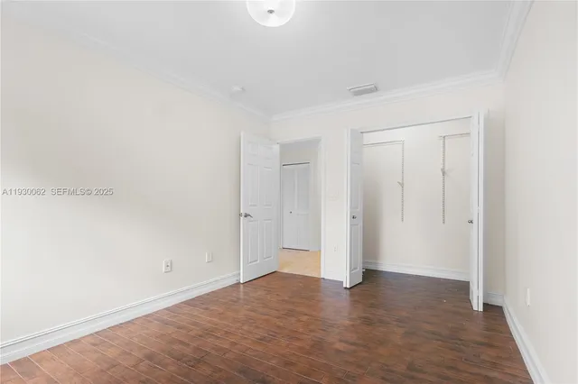 an empty room with wooden floor and window