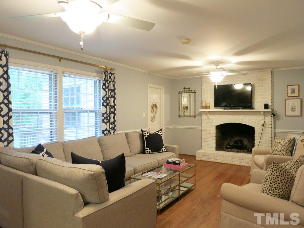 5215 Knollwood Road Raleigh, NC 27609 - Photo 13 of 30 a living room with furniture a fireplace and a flat screen tv