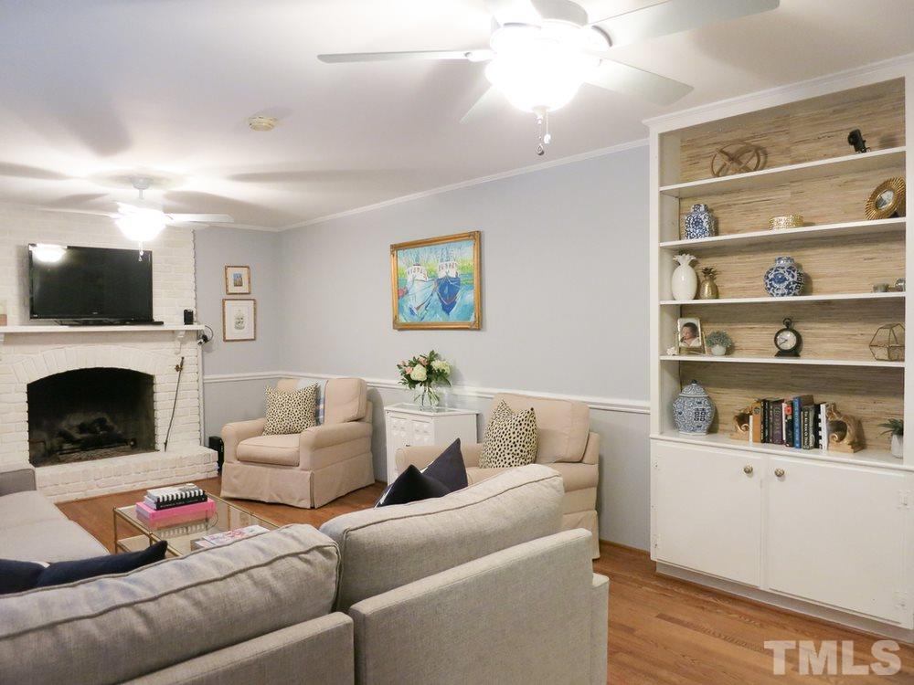 5215 Knollwood Road Raleigh, NC 27609 - Photo 14 of 30 a living room with furniture a flat screen tv and a fireplace