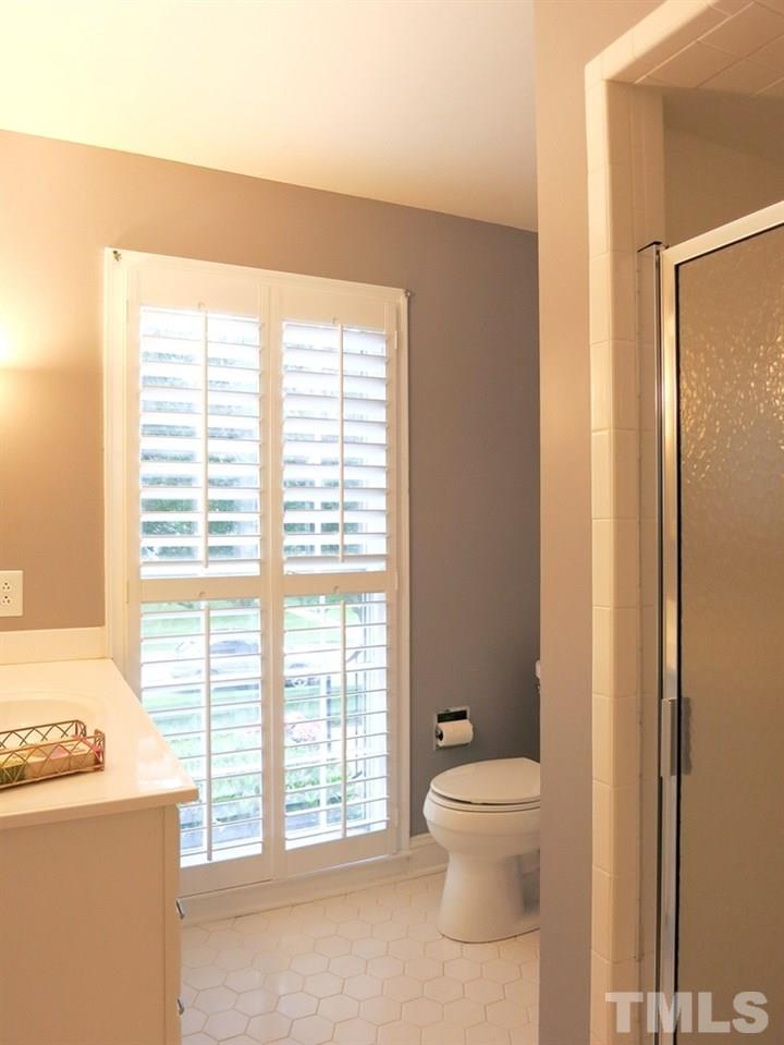5215 Knollwood Road Raleigh, NC 27609 - Photo 19 of 30 a bathroom with a toilet a sink and a window