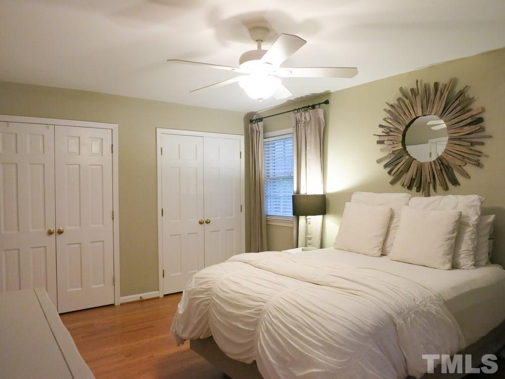 5215 Knollwood Road Raleigh, NC 27609 - Photo 21 of 30 a bedroom with a bed and a chandelier