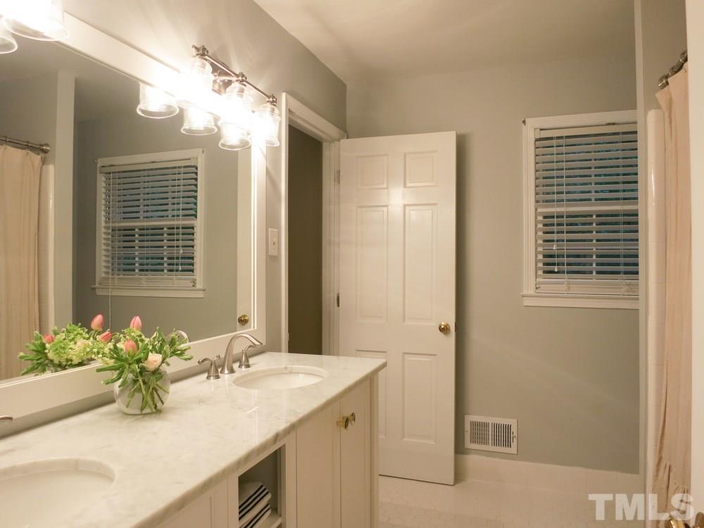 5215 Knollwood Road Raleigh, NC 27609 - Photo 22 of 30 a bathroom with a granite countertop sink and a mirror