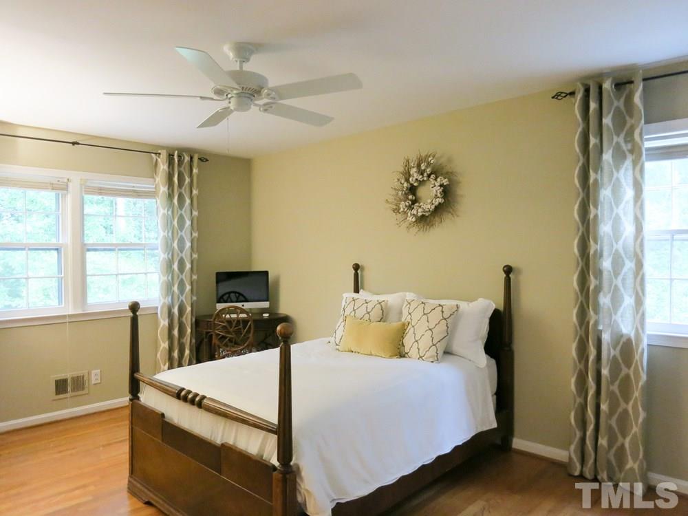 5215 Knollwood Road Raleigh, NC 27609 - Photo 24 of 30 a bedroom with a bed and a chandelier