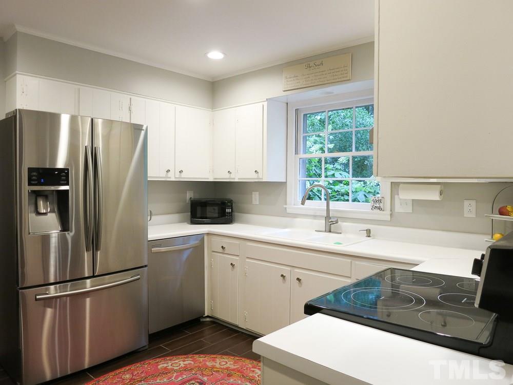 5215 Knollwood Road Raleigh, NC 27609 - Photo 10 of 30 a kitchen with a sink a refrigerator and window