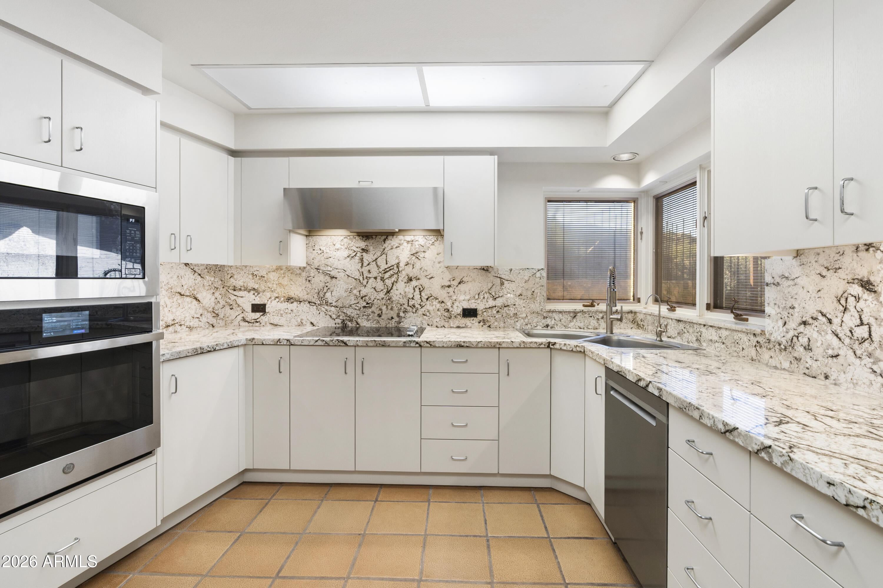 6700 East Hawksnest Road Carefree, AZ 85377 - Photo 18 of 82 a kitchen with granite countertop white cabinets and white appliances