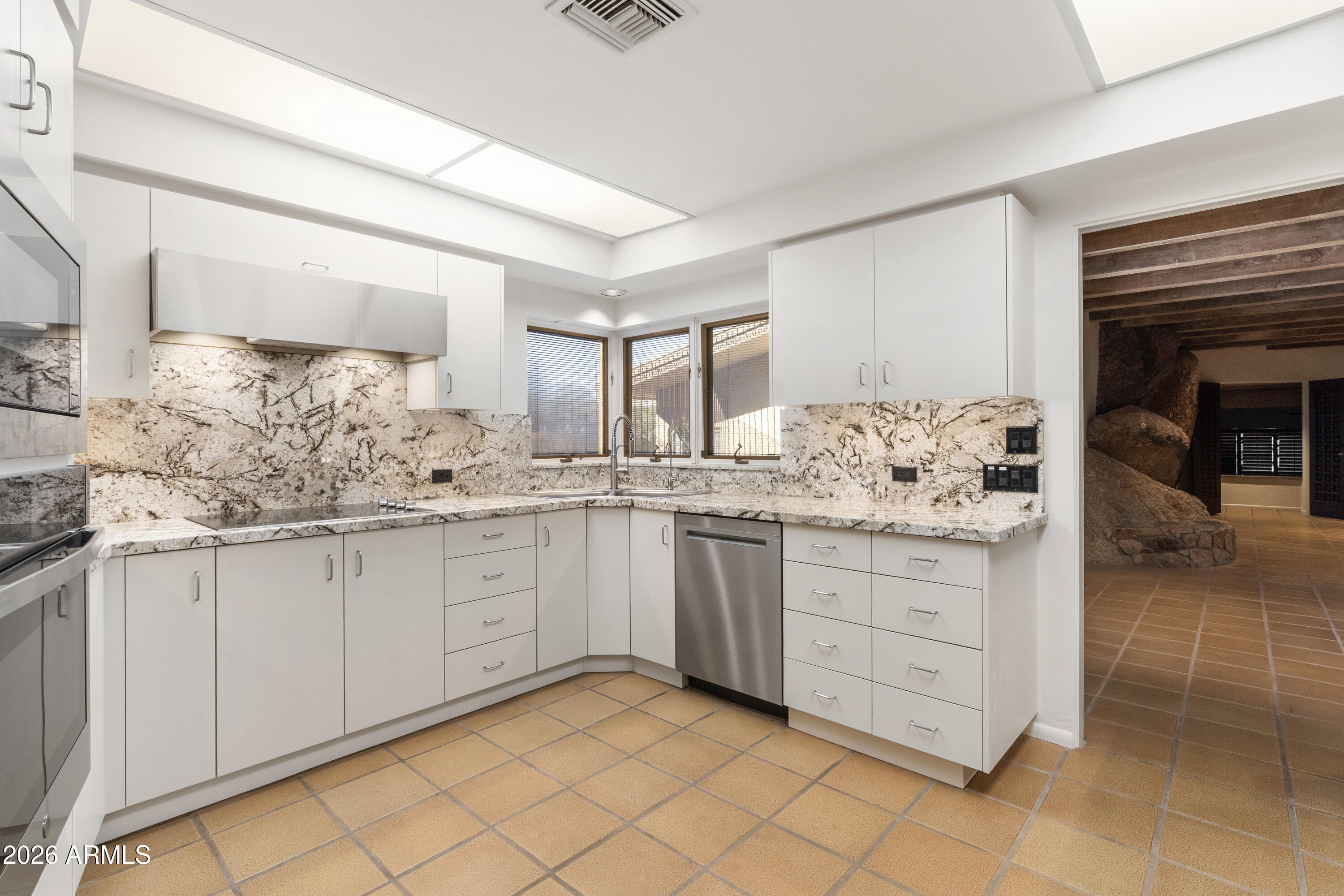 6700 East Hawksnest Road Carefree, AZ 85377 - Photo 19 of 82 a kitchen with granite countertop white cabinets and white appliances