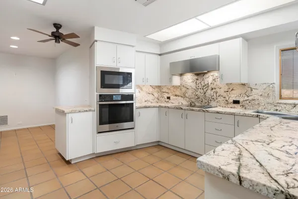 a view of a livingroom with wooden floor and a ceiling fan