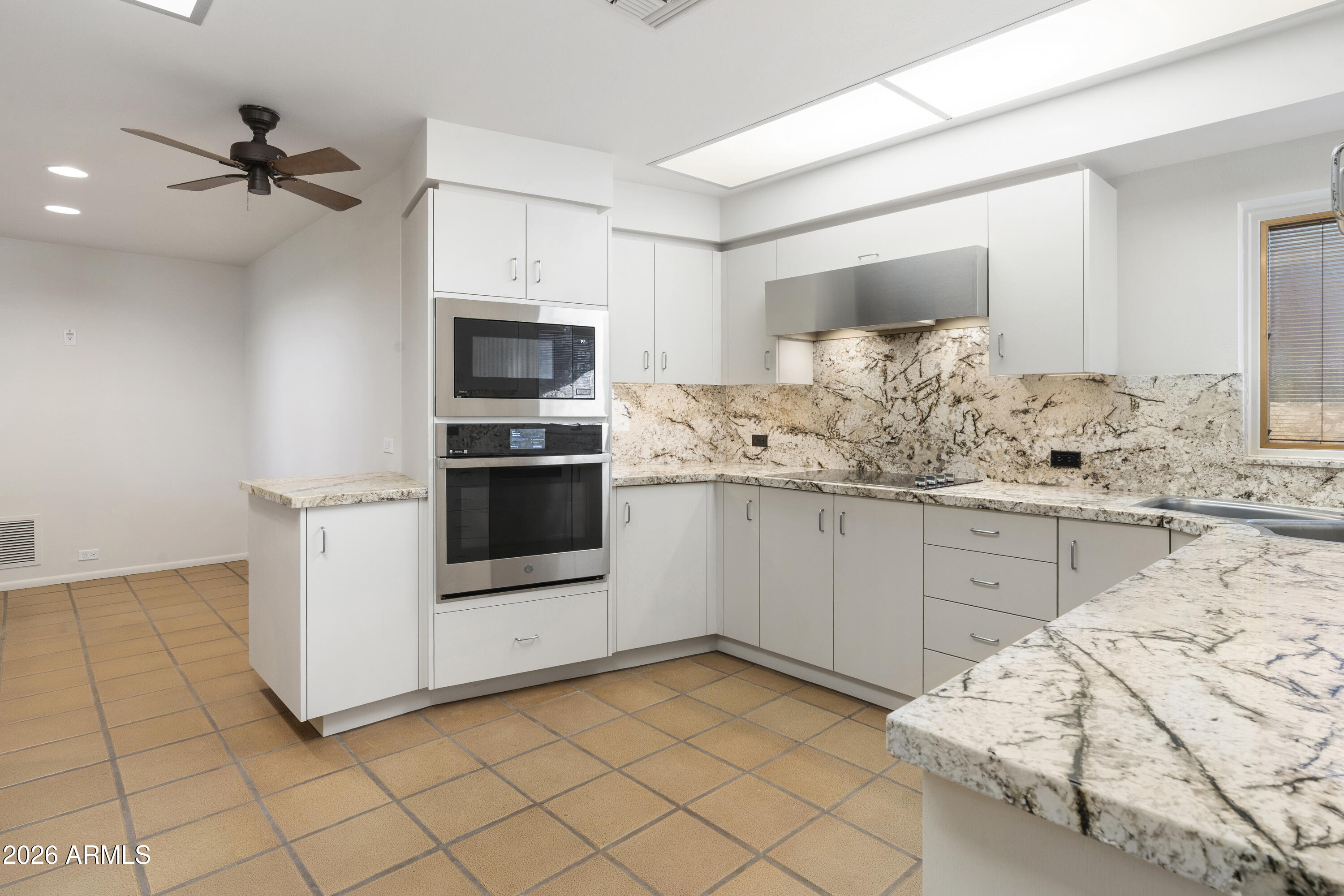 6700 East Hawksnest Road Carefree, AZ 85377 - Photo 21 of 82 a kitchen with granite countertop white cabinets and white appliances