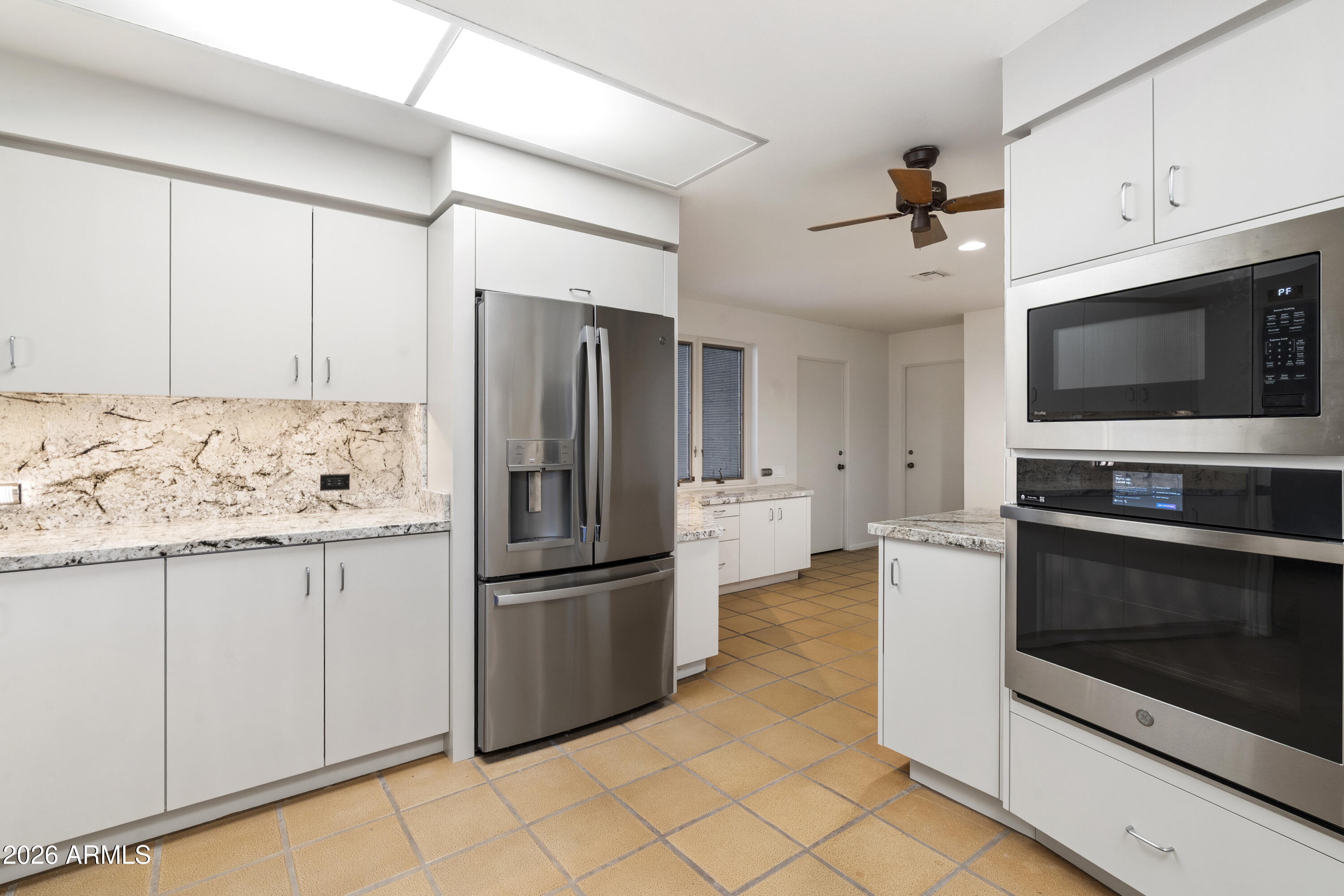 6700 East Hawksnest Road Carefree, AZ 85377 - Photo 22 of 82 a kitchen with granite countertop a refrigerator and a stove top oven