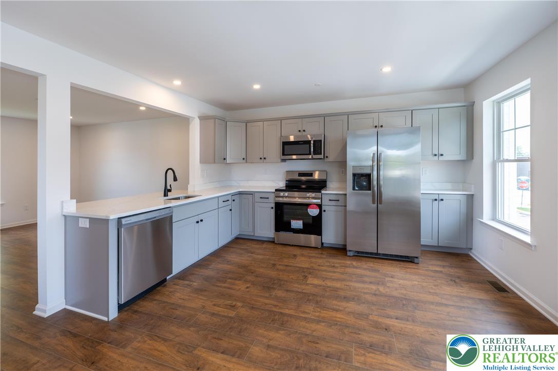 560 Long Street, Unit 1 Emmaus, PA 18049 - Photo 5 of 11 a kitchen with refrigerator cabinets and wooden floor