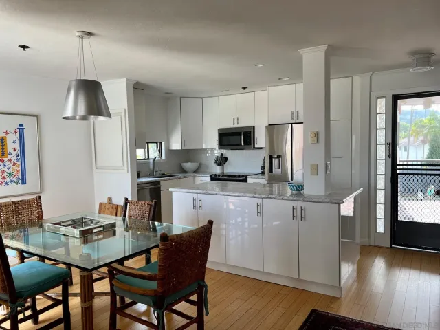 a kitchen with granite countertop white cabinets and stainless steel appliances