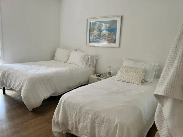 a bedroom with two beds and wooden floor