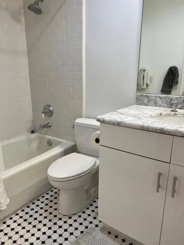 a bathroom with a granite countertop toilet a sink and a bathtub