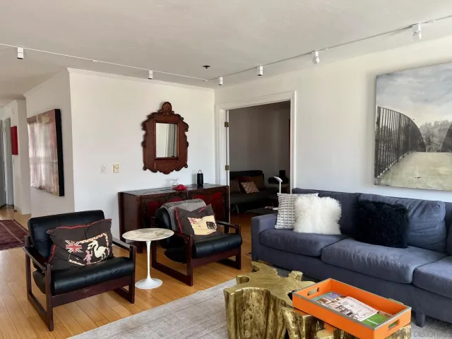 a living room with furniture and a wooden floor