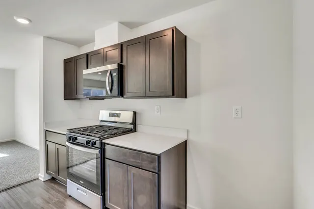 a kitchen with stainless steel appliances cabinets and a window