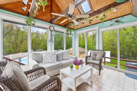 a living room with patio furniture and a flat screen tv