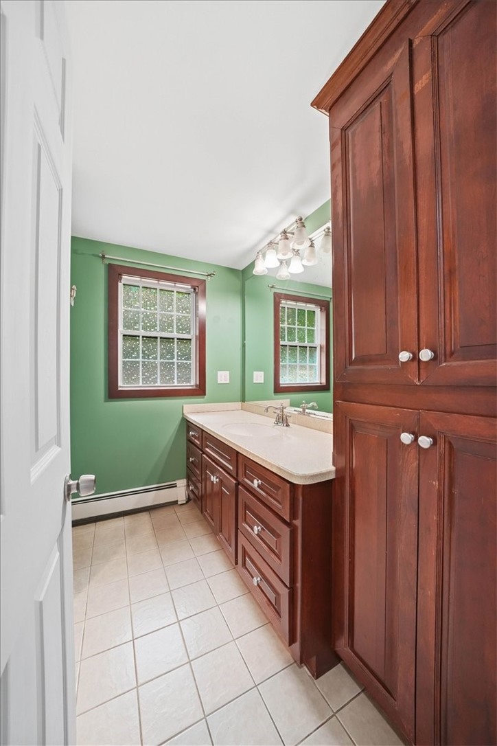 214 Anan Wade Road Glocester, RI 02857 - Photo 23 of 50 full bathroom is spacious, functional, and exceptionally well equipped with storage. A long vanity provides generous counter space and multiple drawers and cabinets, while a substantial floor-to-ceiling built-in storage cabinet adds even more room for towels, linens, toiletries, and everyday essentials.