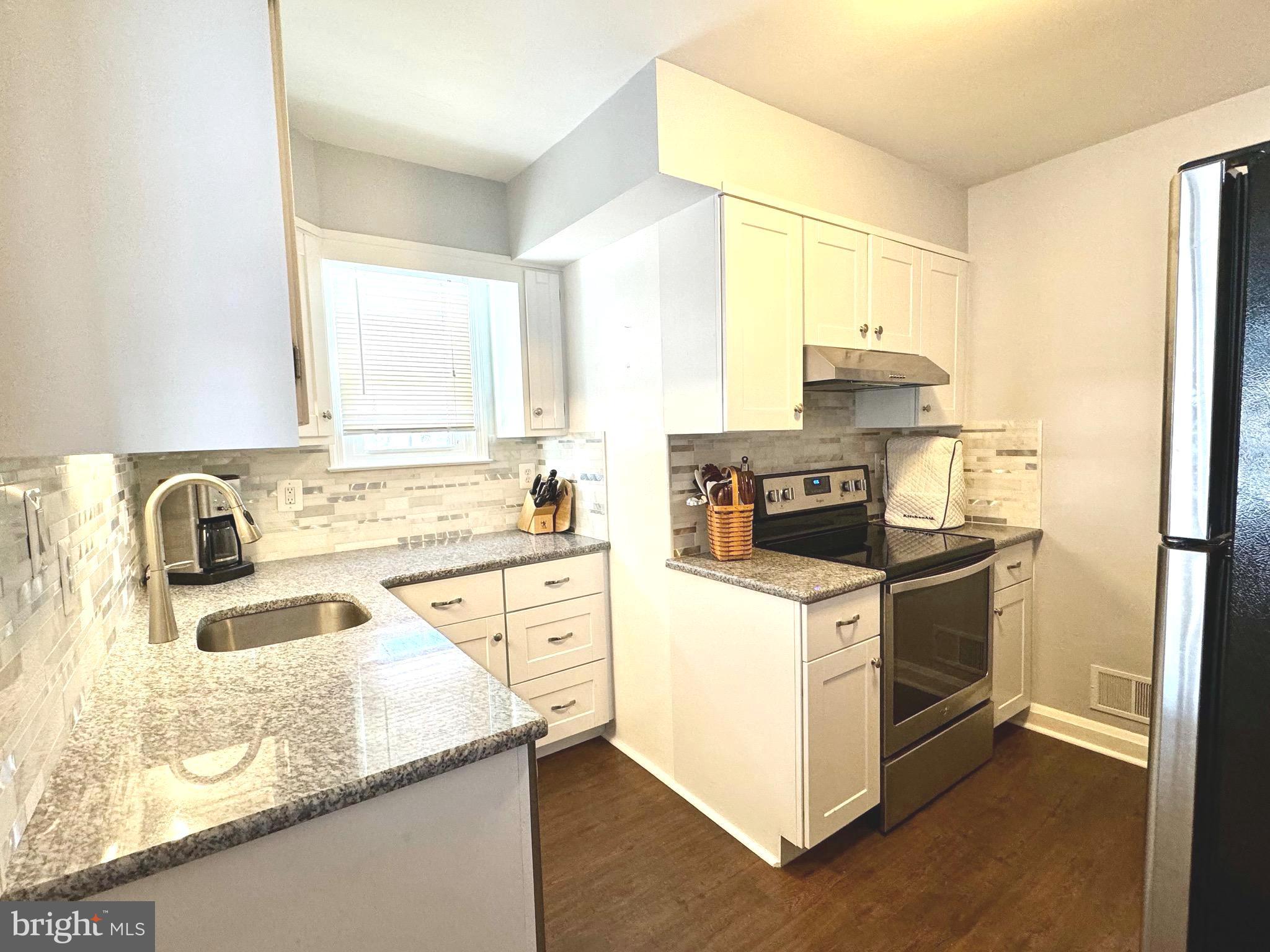 500 Milford Mill Road Pikesville, MD 21208 - Photo 12 of 43 a kitchen with granite countertop a sink stove and cabinets