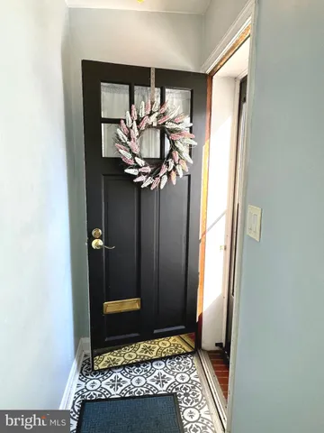 a view of a hallway with wooden floor and a bathroom