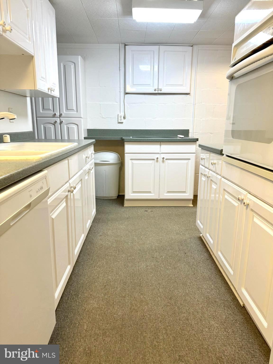 500 Milford Mill Road Pikesville, MD 21208 - Photo 23 of 43 a kitchen with white cabinets and white appliances