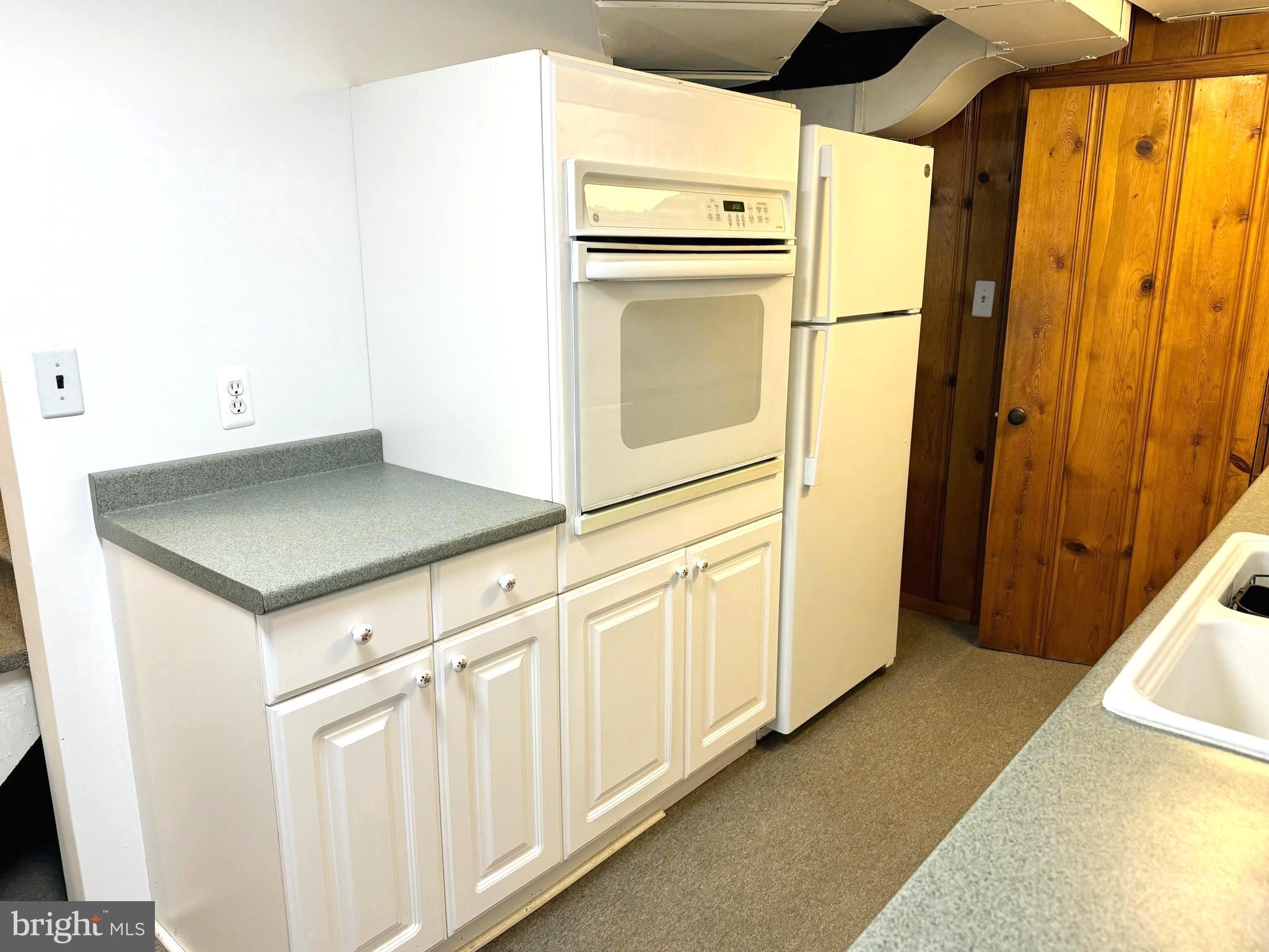 500 Milford Mill Road Pikesville, MD 21208 - Photo 24 of 43 a kitchen with white cabinets and wooden floor