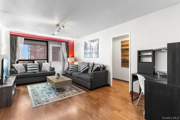a living room with furniture flat screen tv and a window