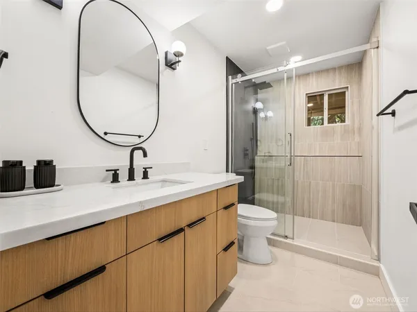a bathroom with a sink a toilet and a mirror