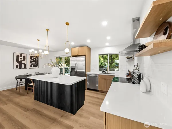 a kitchen with a sink a counter space and living room view