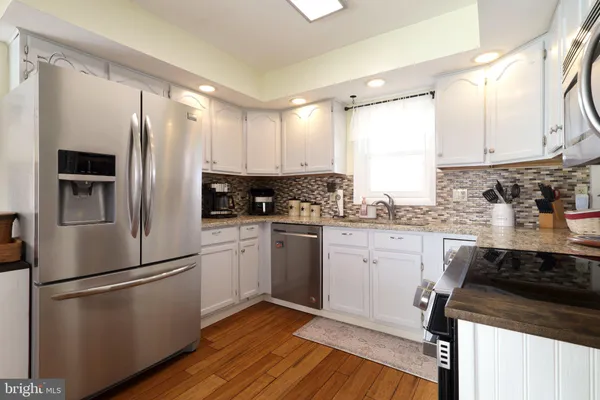 a kitchen with a table chairs refrigerator and microwave