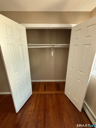 a view of walk in closet with wooden floor and stairs
