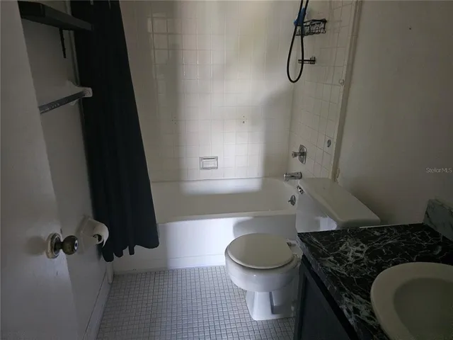 a view of a big room with windows and chandelier fan