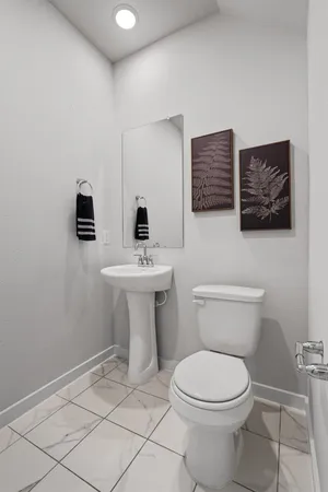 a bathroom with a toilet a sink and mirror