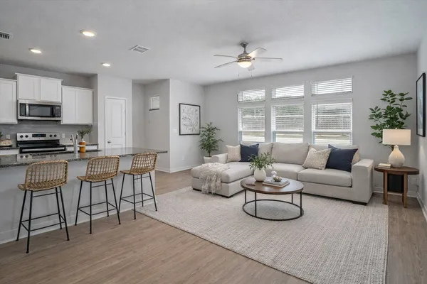 a living room with furniture and a wooden floor