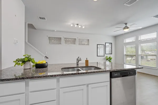 a kitchen with granite countertop a counter top space and windows