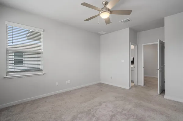 an empty room with a window and a fan