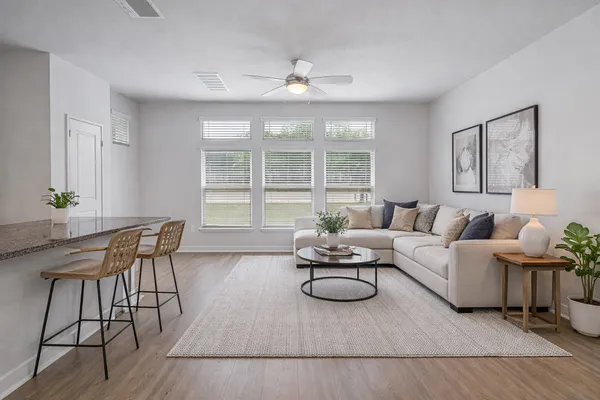 a living room with furniture a large window and a table