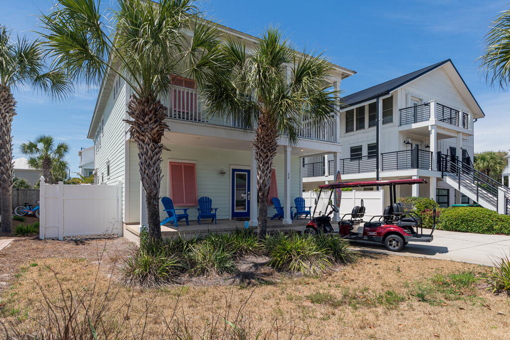 64 Dolphin Street Destin, FL 32541 - Photo 22 of 107 a front view of a house with garden and trees