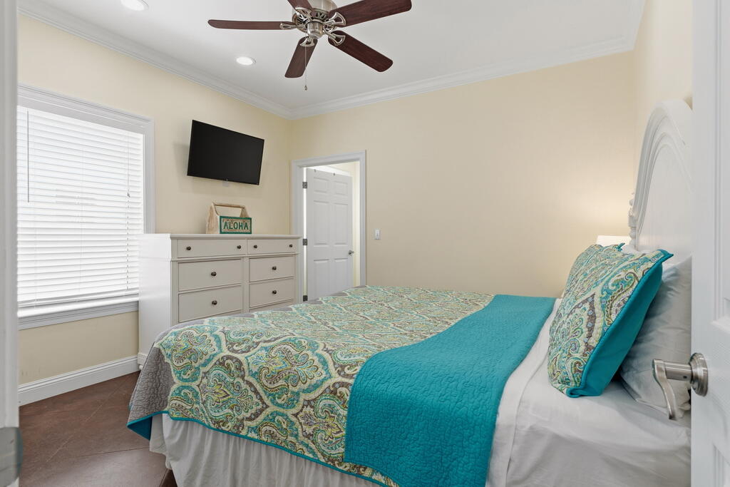 64 Dolphin Street Destin, FL 32541 - Photo 37 of 107 a bedroom with a bed and a flat screen tv
