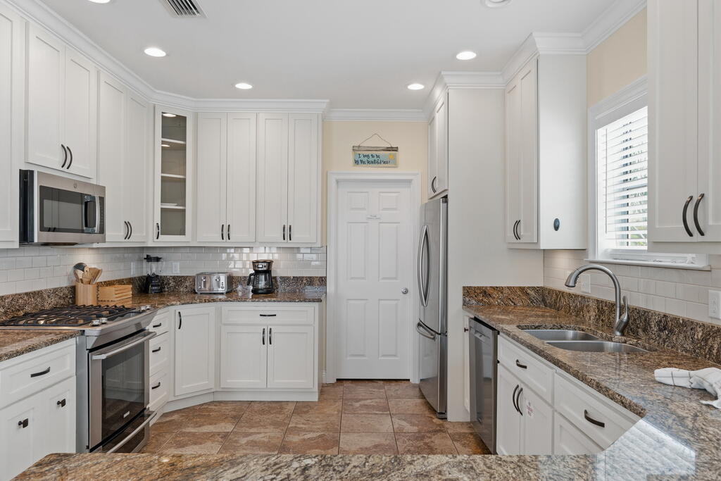 64 Dolphin Street Destin, FL 32541 - Photo 53 of 107 a kitchen with a sink stove and refrigerator