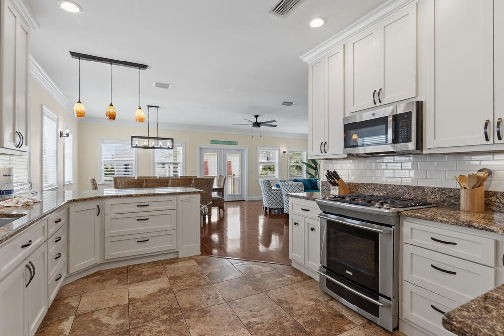 64 Dolphin Street Destin, FL 32541 - Photo 54 of 107 a kitchen with granite countertop a stove top oven microwave and cabinets