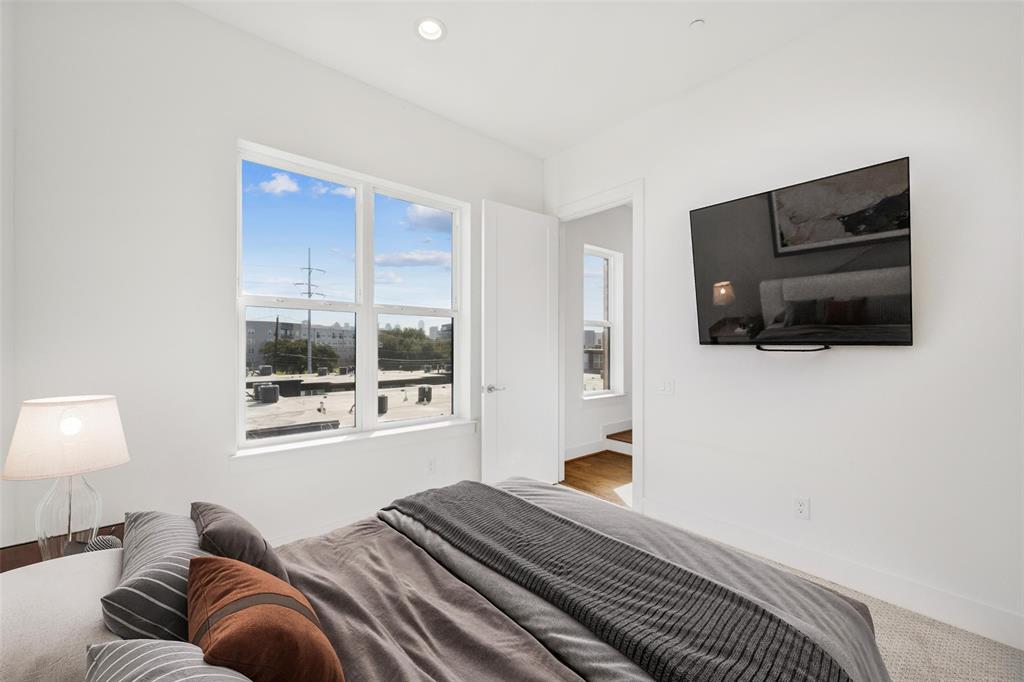 3064 ChImes Street Dallas, TX 75219 - Photo 23 of 40 a bedroom with a bed and wooden floor