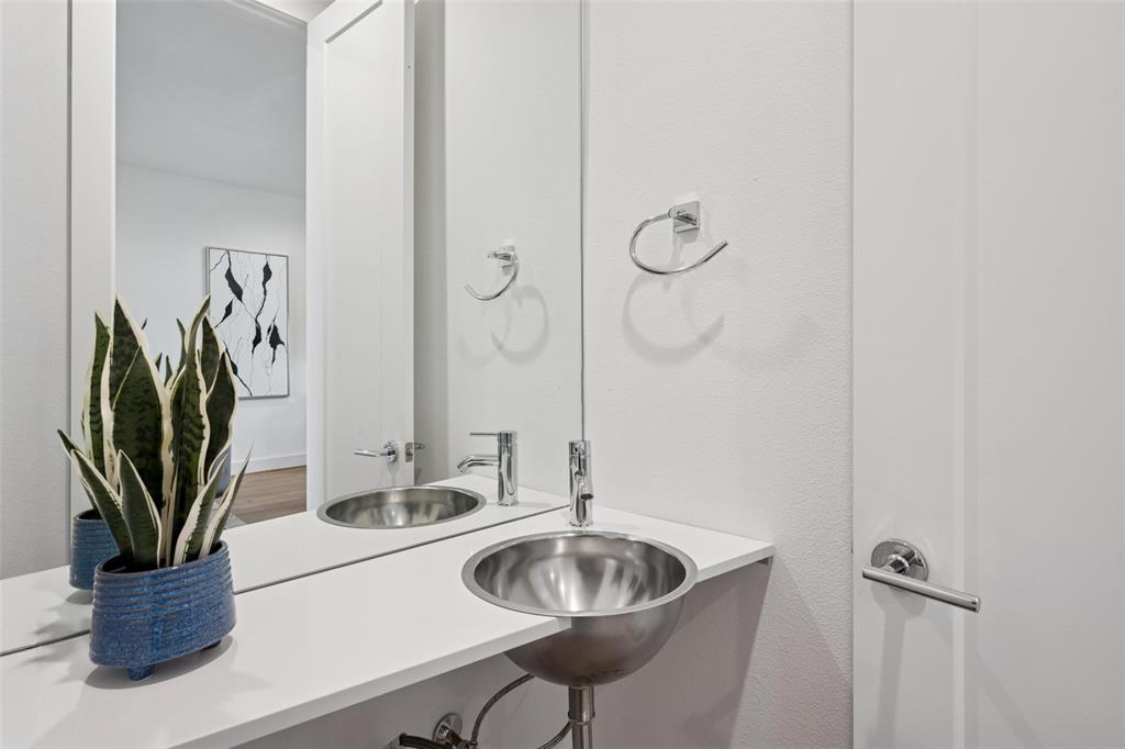 3064 ChImes Street Dallas, TX 75219 - Photo 32 of 40 a bathroom with a sink a potted plant and a mirror