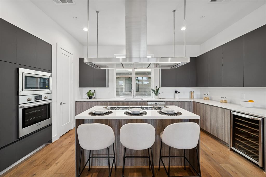 3064 ChImes Street Dallas, TX 75219 - Photo 9 of 40 a kitchen with a dining table chairs stainless steel appliances and cabinets