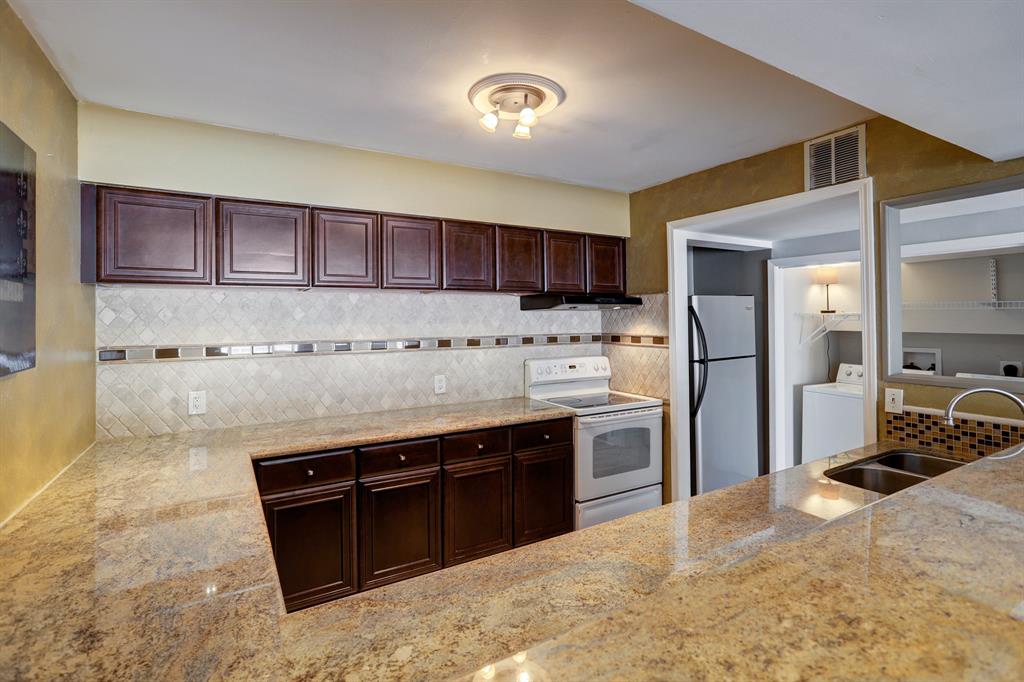 a kitchen with stainless steel appliances granite countertop a stove refrigerator and a sink