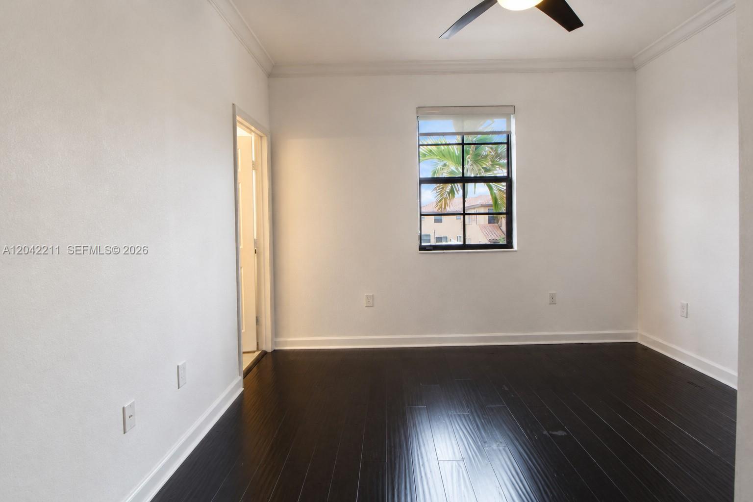 8954 West 35th Way Hialeah, FL 33018 - Photo 15 of 24 an empty room with wooden floor and windows